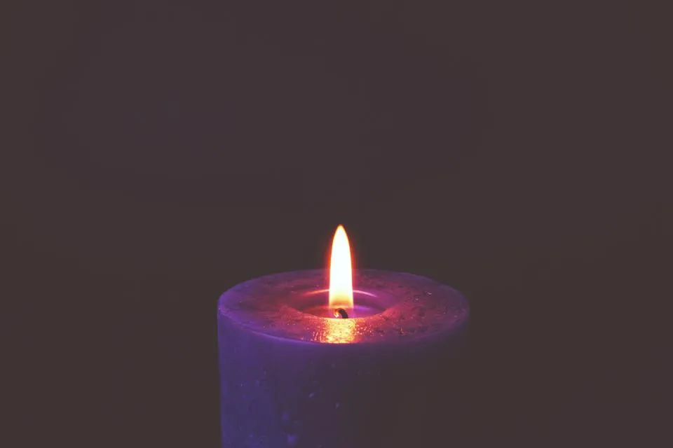 A single memorial candle glowing softly in remembrance